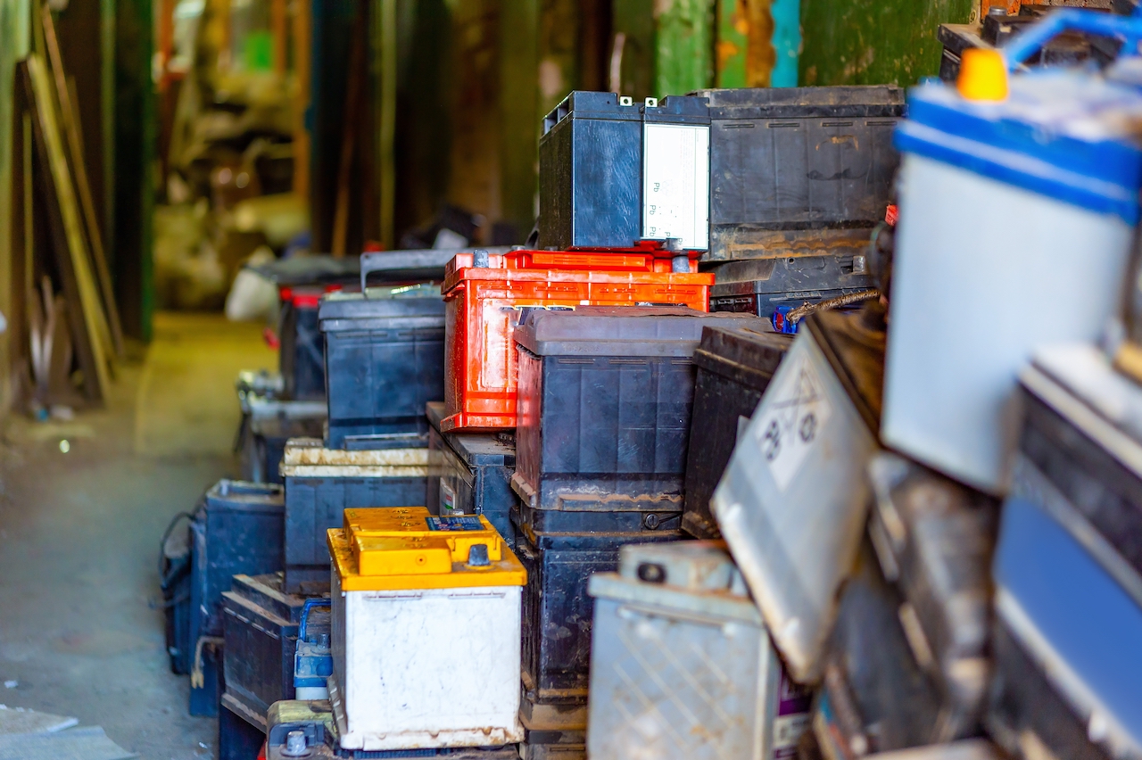 a bunch of used car batteries piled up